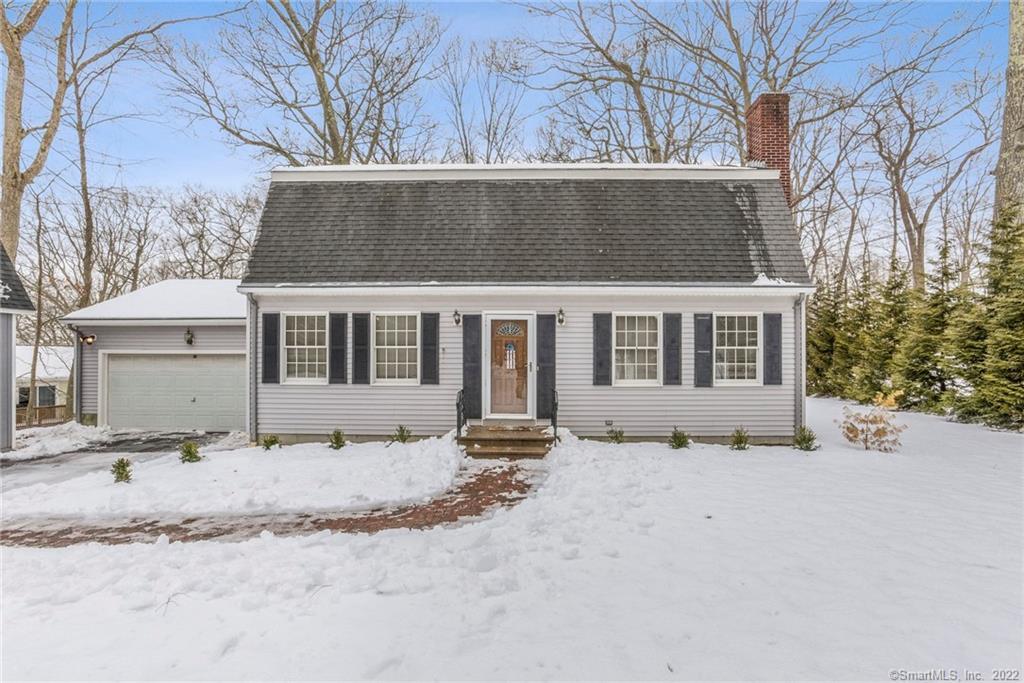 a front view of a house with a yard covered in snow