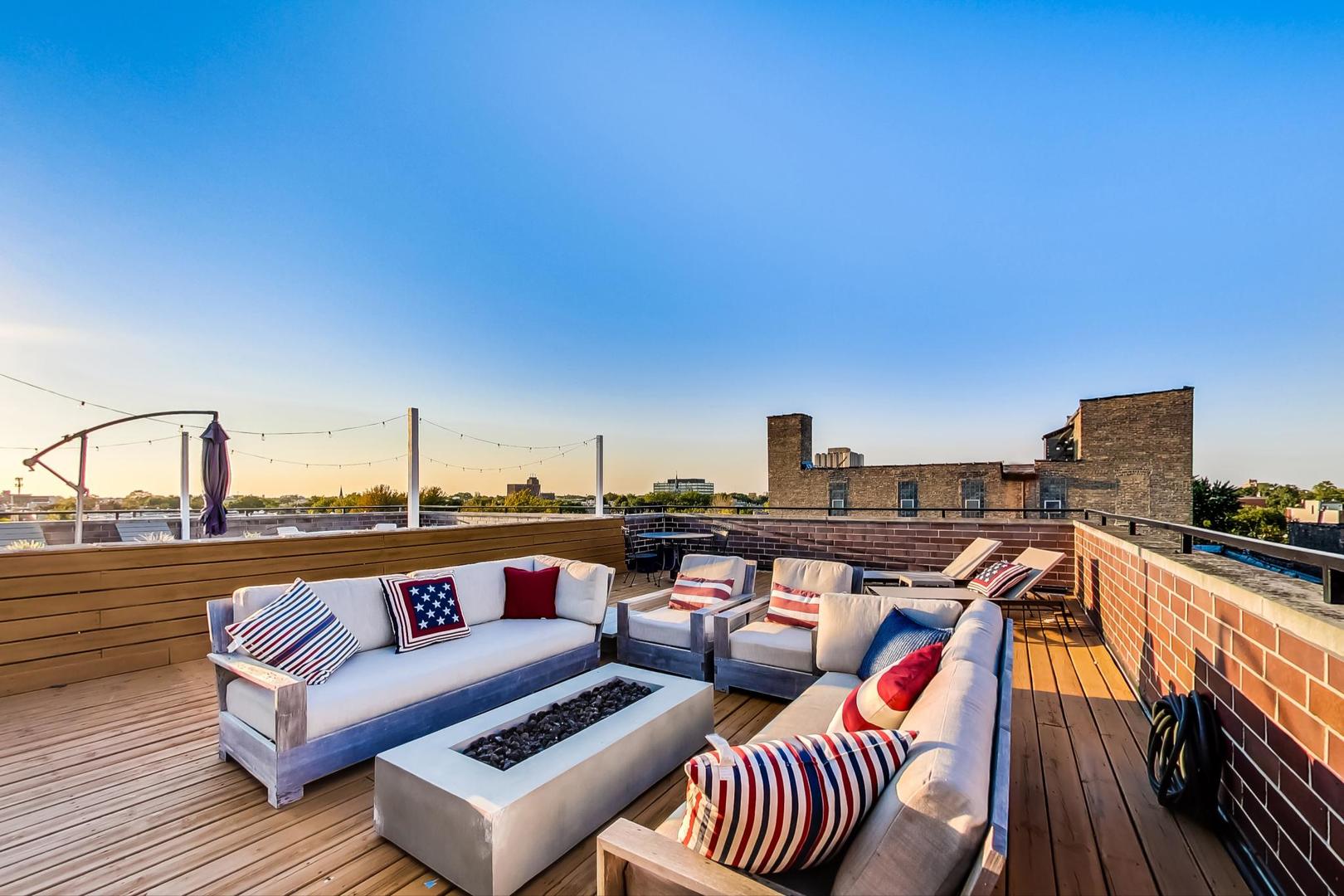 2144 West Rice Street, Unit 3E Chicago, IL 60622 - Photo 15 of 19 a roof deck with couches and wooden floor