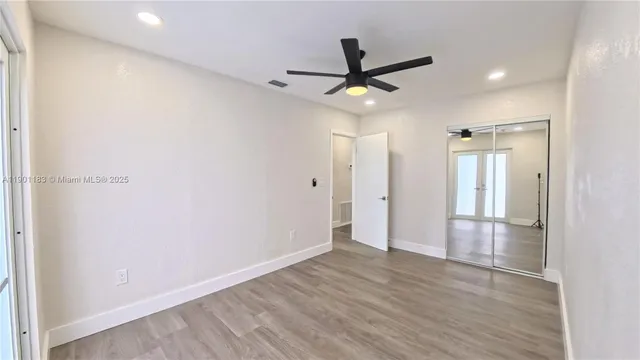 a view of a livingroom with a ceiling fan & wooden floor