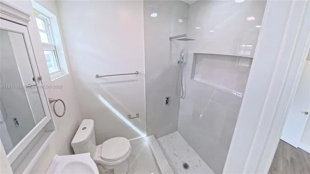 a bathroom with a toilet and a shower