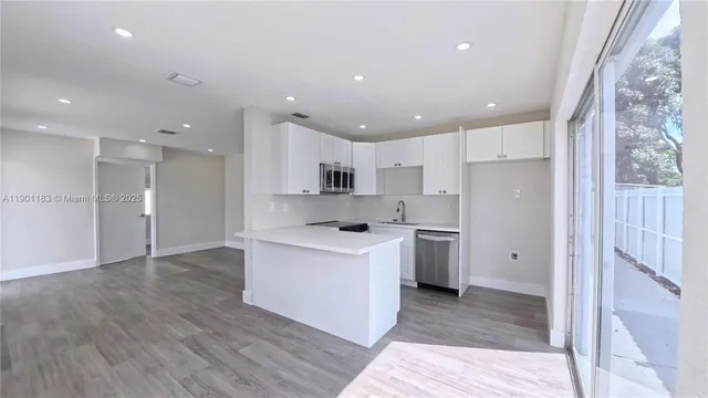 a open kitchen with a refrigerator a sink and a stove top oven
