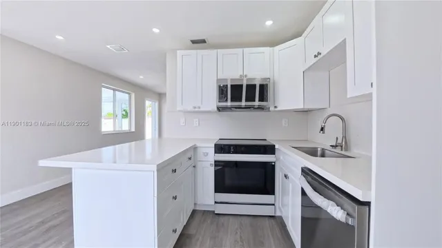 a kitchen with stainless steel appliances granite countertop a sink stove and microwave
