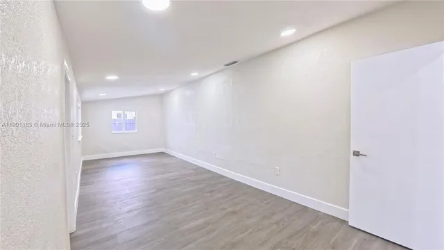 a view of an empty room with wooden floor