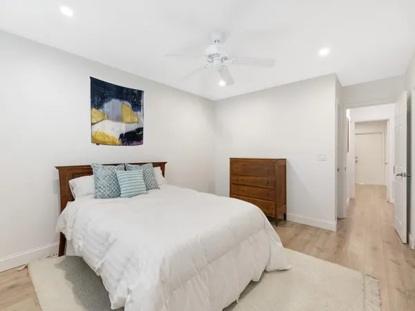 a view of empty room with wooden floor and ceiling fan