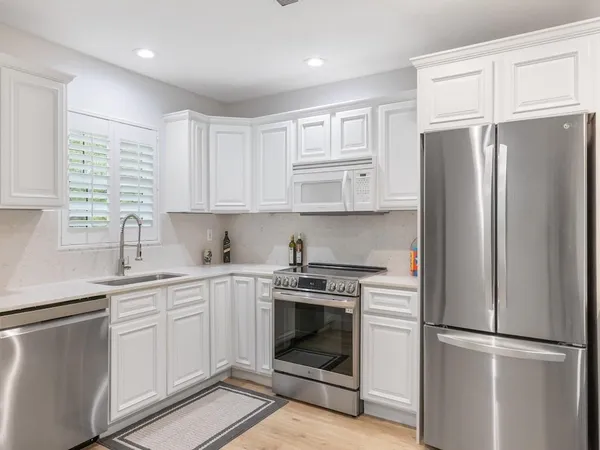 a kitchen with stainless steel appliances granite countertop a refrigerator stove and sink