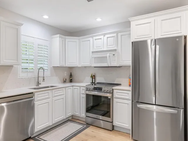 a kitchen with stainless steel appliances granite countertop a refrigerator stove and sink