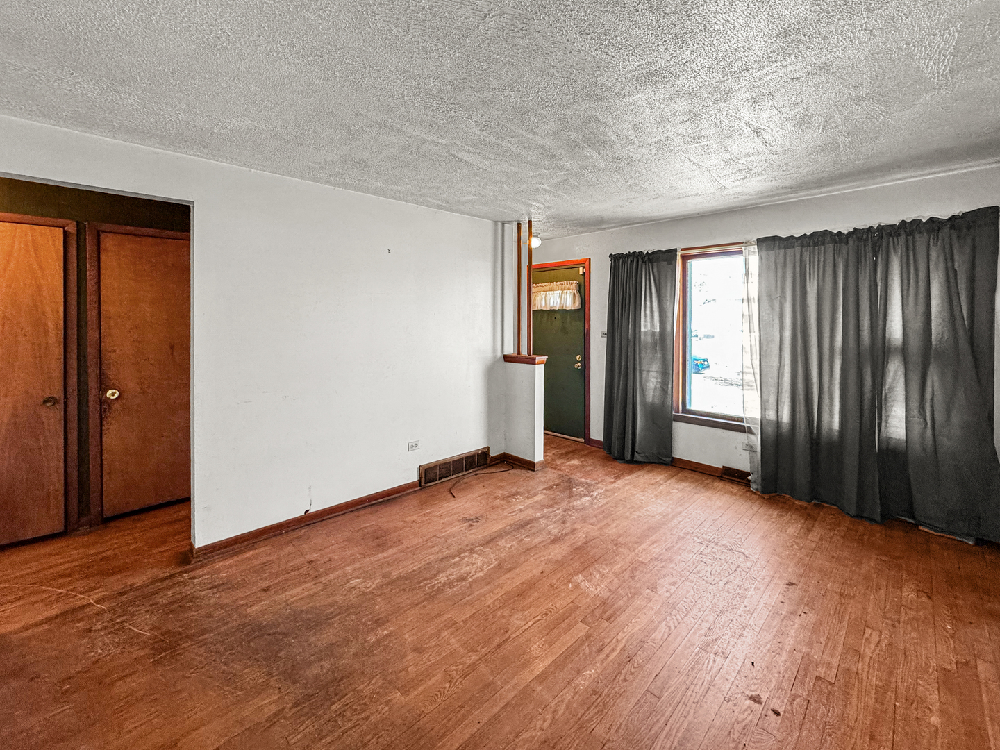 12326 South Indiana Avenue Chicago, IL 60628 - Photo 5 of 14 an empty room with wooden floor and windows