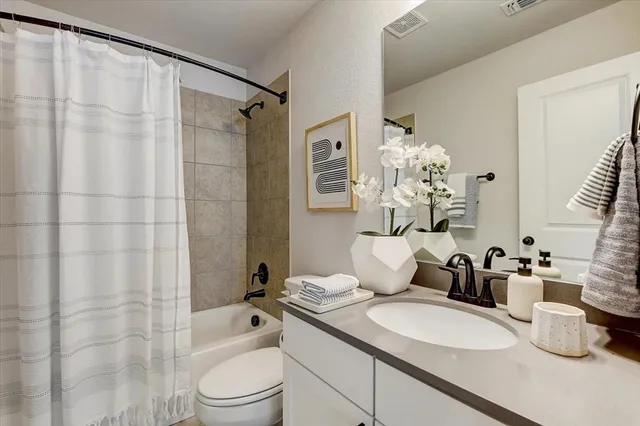 a bathroom with a double vanity sink toilet mirror and shower