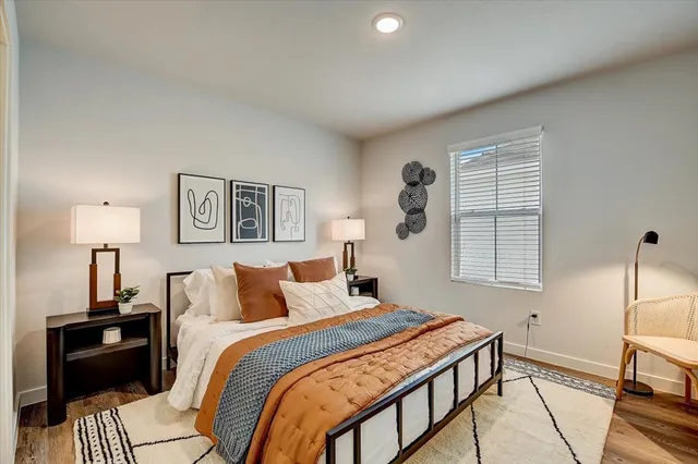 a kitchen with kitchen island a refrigerator stove and white cabinets with wooden floor