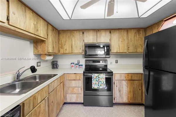 a kitchen with a sink a refrigerator and cabinets