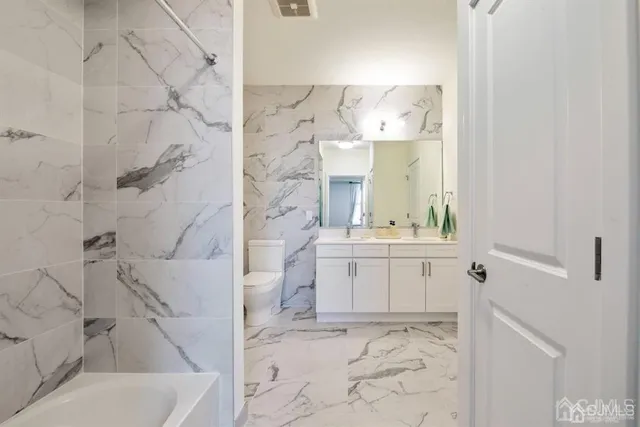 a bathroom with a toilet sink and mirror