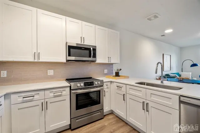 a kitchen with white cabinets and white appliances