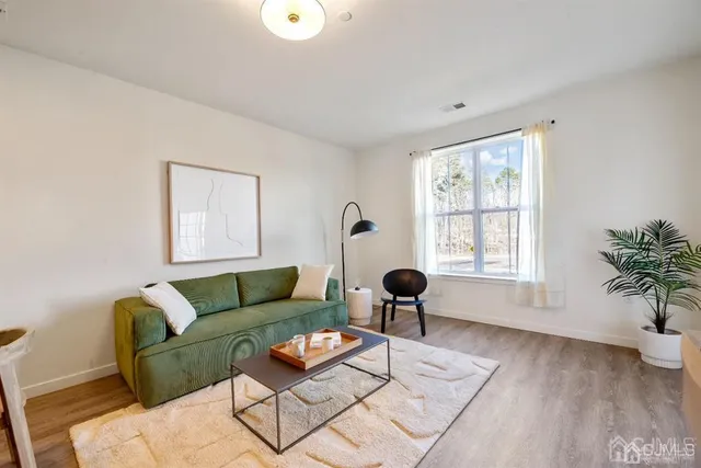 a living room with furniture and a dining table with wooden floor