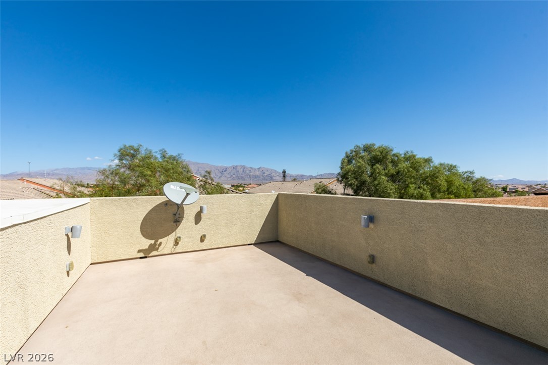 4650 Ranch House Road, Unit 46 North Las Vegas, NV 89031 - Photo 31 of 38 Take in distant mountain views from this elevated stucco-walled rooftop terrace under clear blue skies.