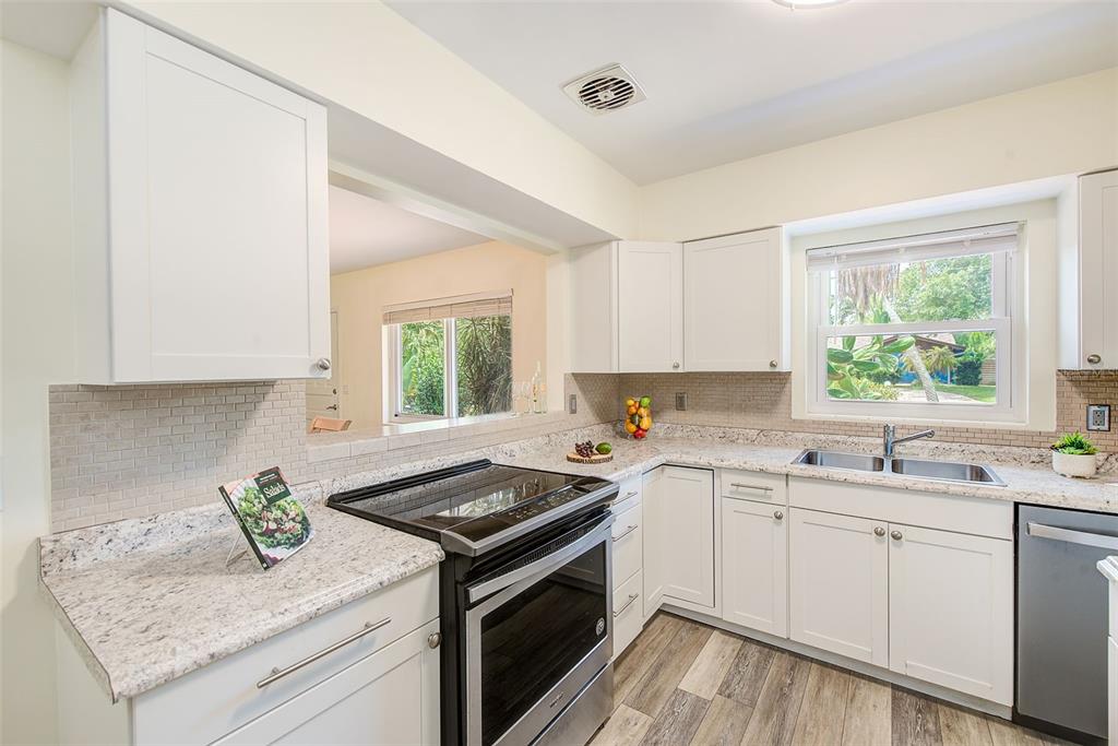 14079 Victoria Road Largo, FL 33774 - Photo 10 of 46 a kitchen with a sink stove and cabinets
