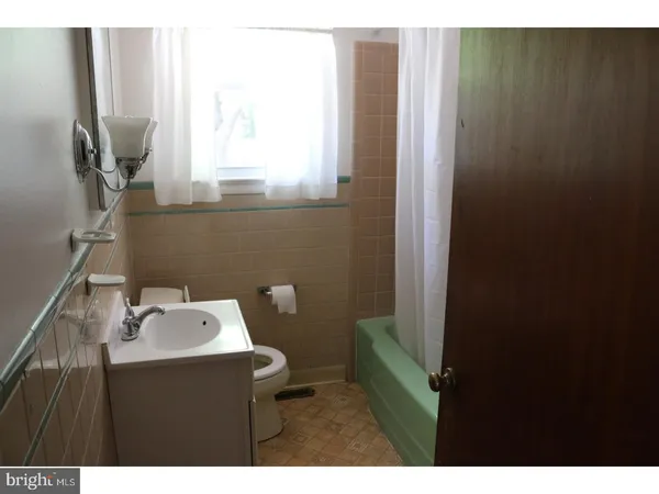 a bathroom with a sink toilet and window