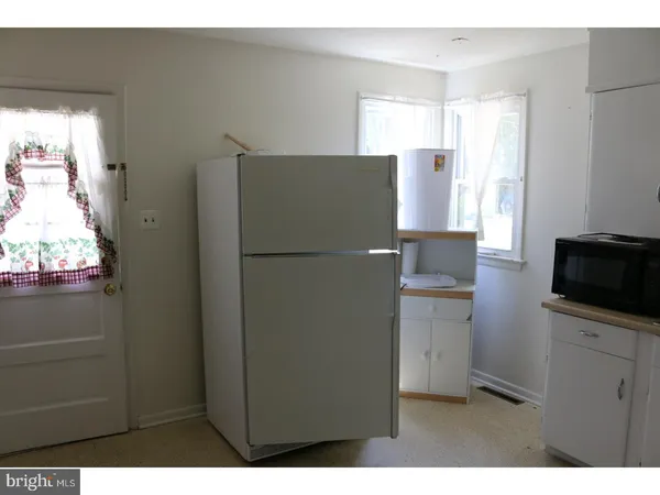 a kitchen with a refrigerator and a stove top oven