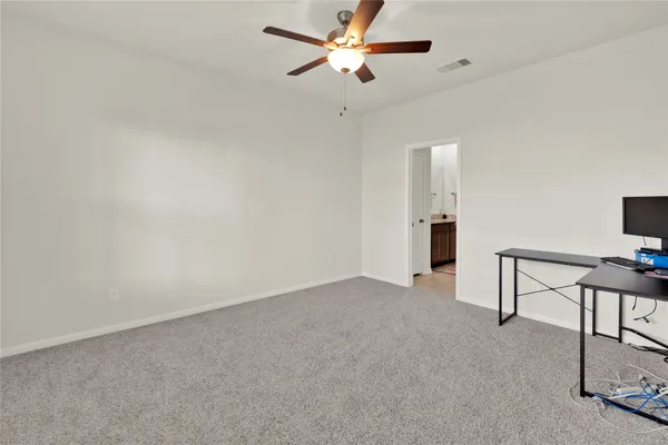 a view of an empty room with a ceiling fan