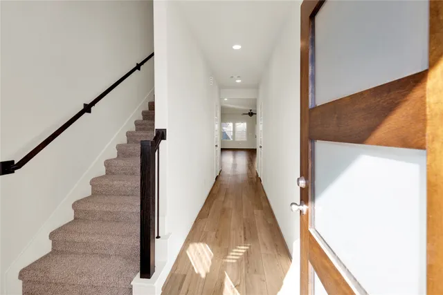 a view of a hallway with wooden floor and staircase