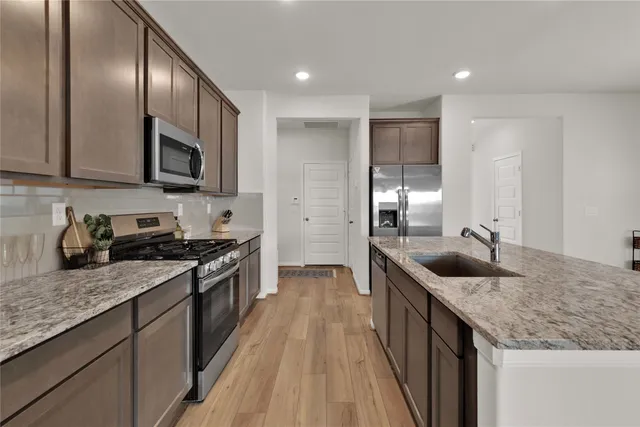 a kitchen with granite countertop stainless steel appliances and wooden cabinets