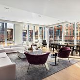a living room with furniture and floor to ceiling windows