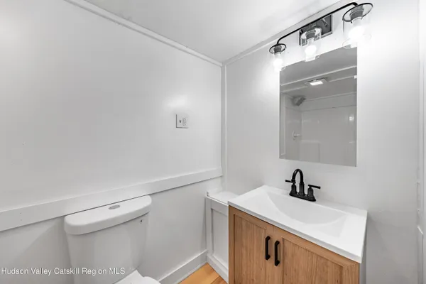a bathroom with a sink a toilet and mirror