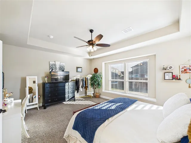 a spacious bedroom with a bed and a chandelier