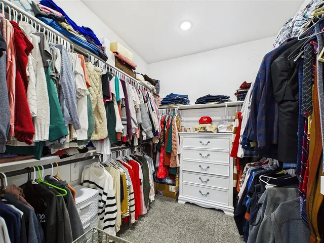 a view of walk in closet with clothes