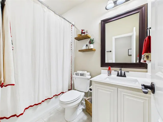 a bathroom with a sink vanity mirror and toilet
