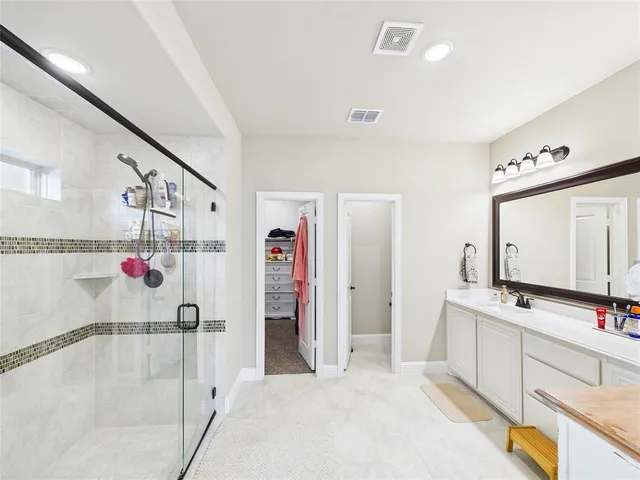 a bathroom with a tub sink a mirror and a shower