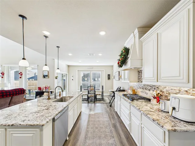 a large kitchen with kitchen island granite countertop a large counter top a sink stainless steel appliances and cabinets