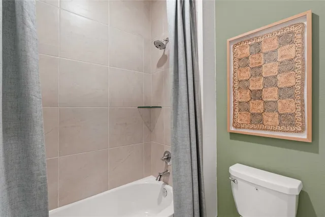 a bathroom with a toilet and a shower