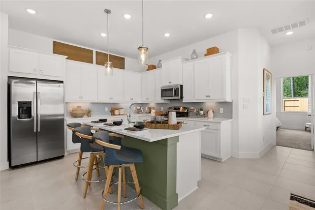 a kitchen that has a lot of cabinets in it and appliances