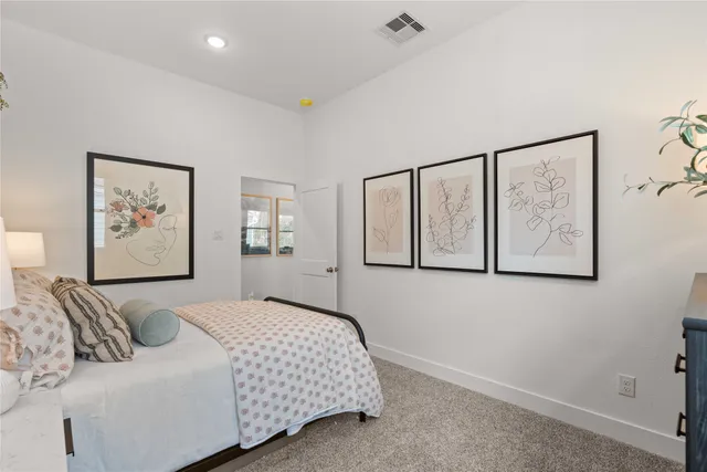 a bedroom with a bed and painting on the wall