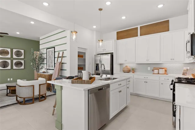 a view of a kitchen with center island stainless steel appliances a table and a window