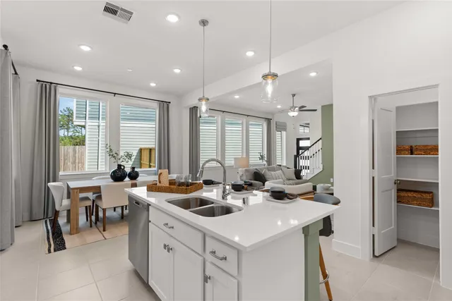 a kitchen with a sink a counter top space and living room view