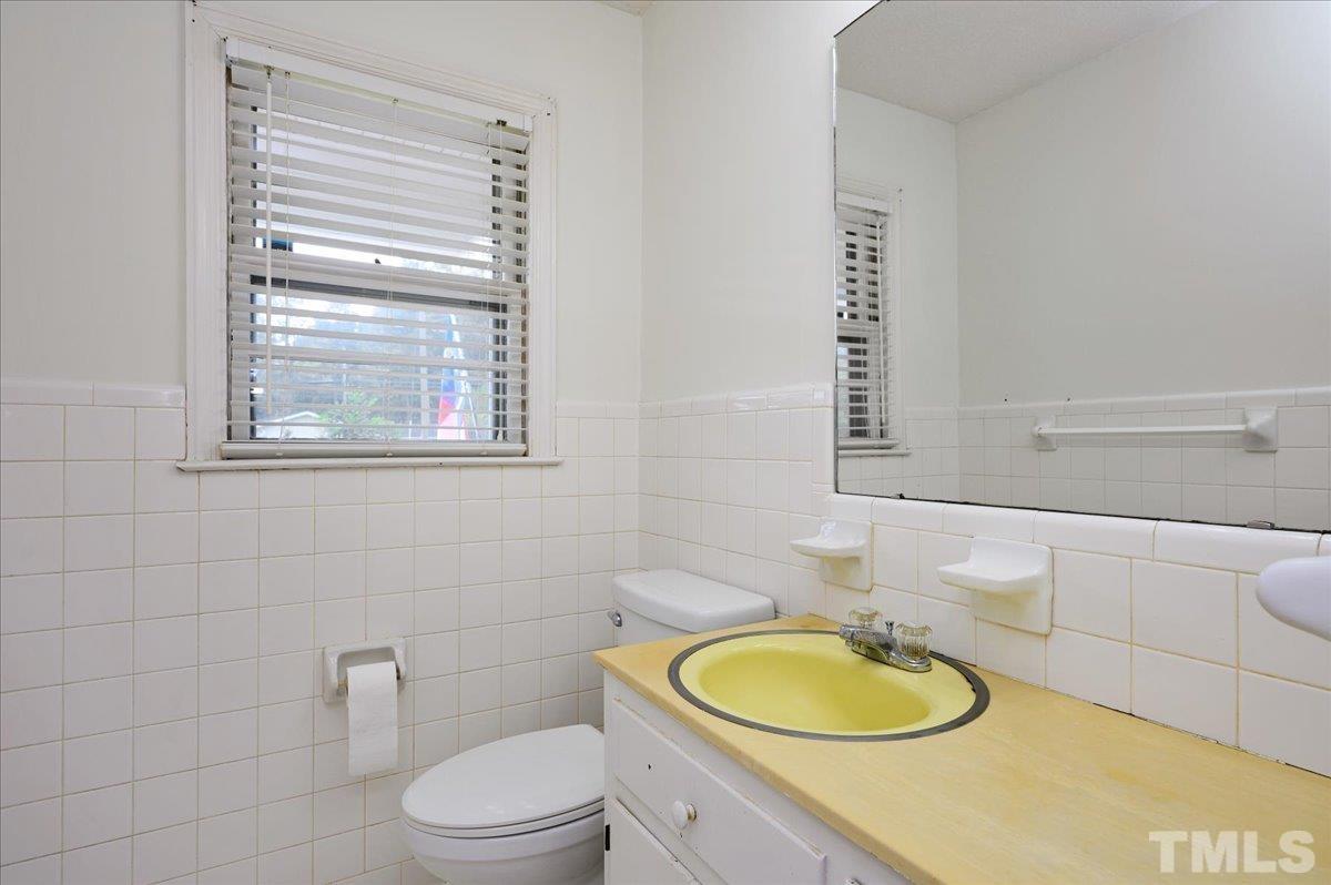 755 Wait Avenue Wake Forest, NC 27587 - Photo 16 of 23 a bathroom with a toilet a sink and a mirror