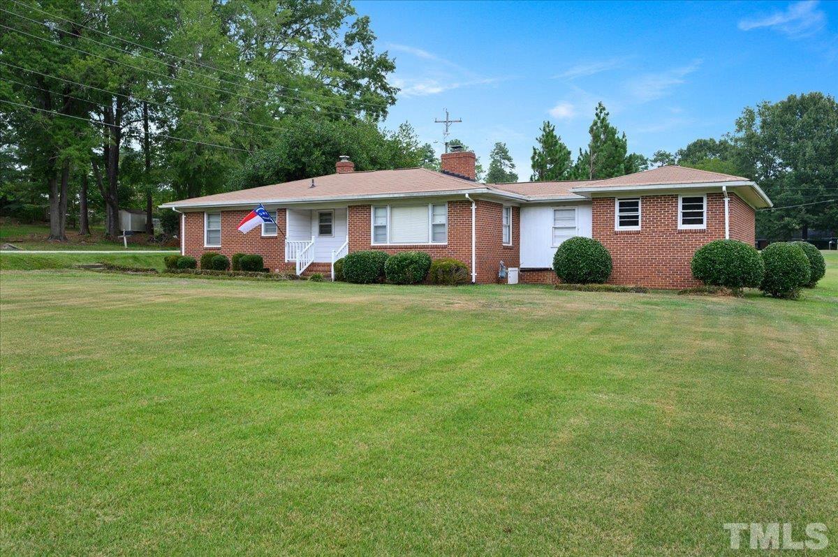 755 Wait Avenue Wake Forest, NC 27587 - Photo 2 of 23 a view of a yard in front of a house with plants and large tree