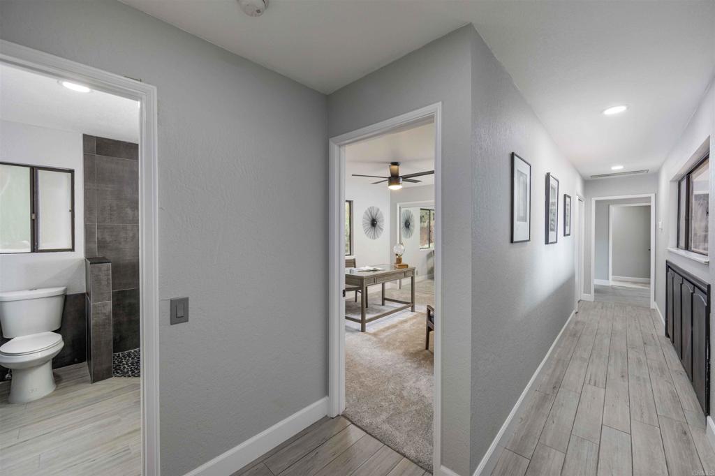 32404 Womsi Road Pauma Valley, CA 92061 - Photo 21 of 34 a view of a hallway with wooden floor and a living room