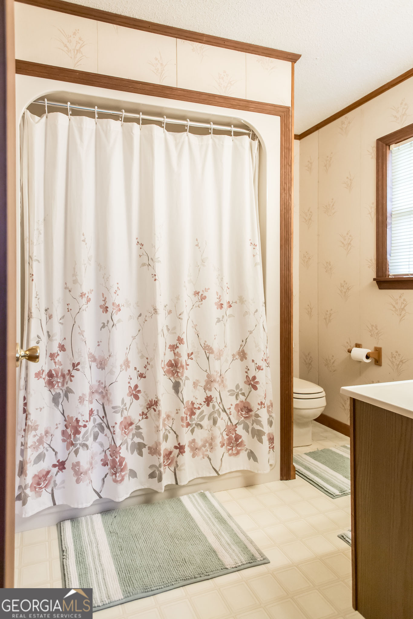 1917 Gilchrist Avenue Waycross, GA 31503 - Photo 22 of 42 a bathroom with a granite countertop sink a toilet and a shower curtain