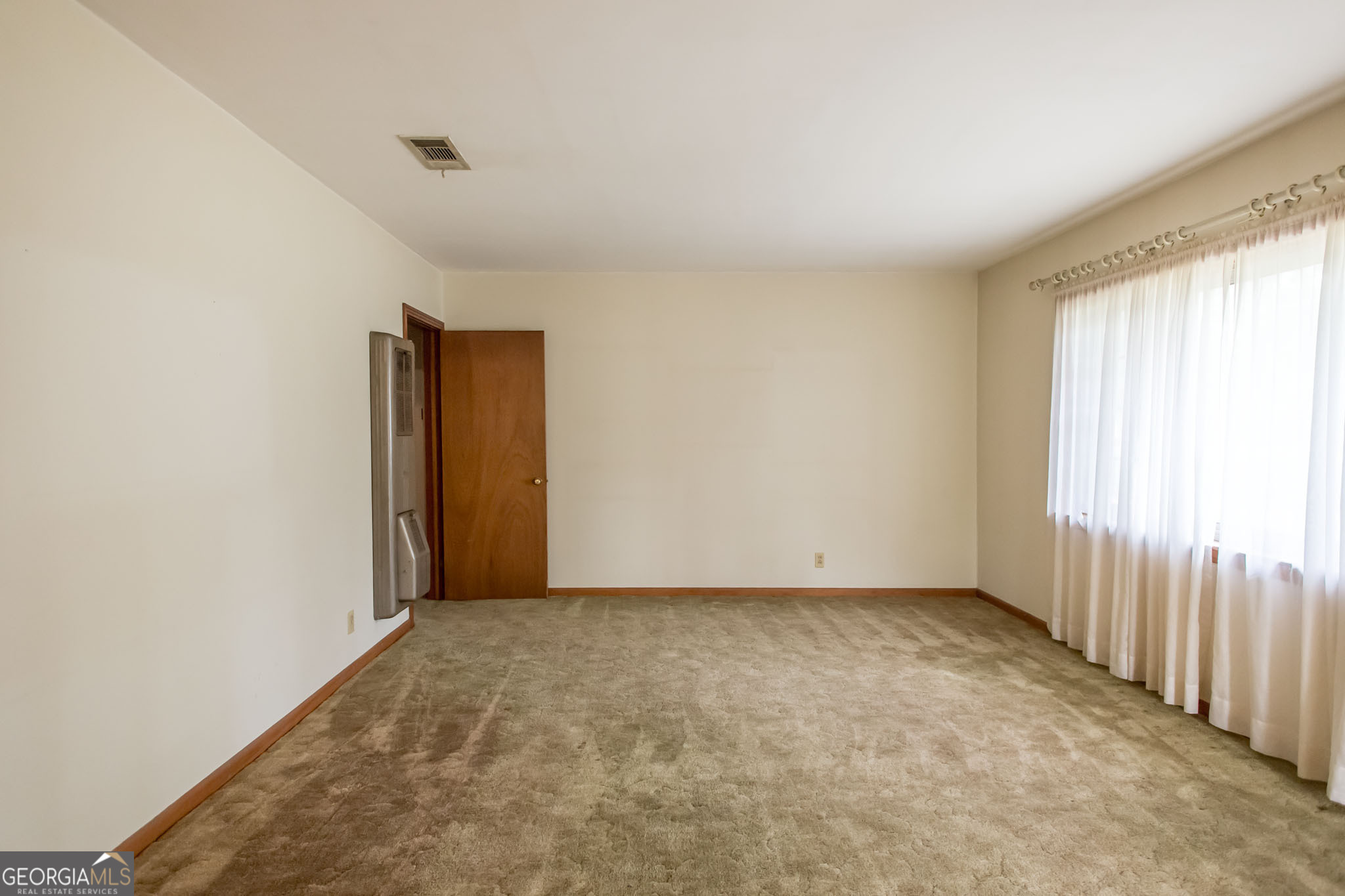 1917 Gilchrist Avenue Waycross, GA 31503 - Photo 6 of 42 a view of an empty room with a window
