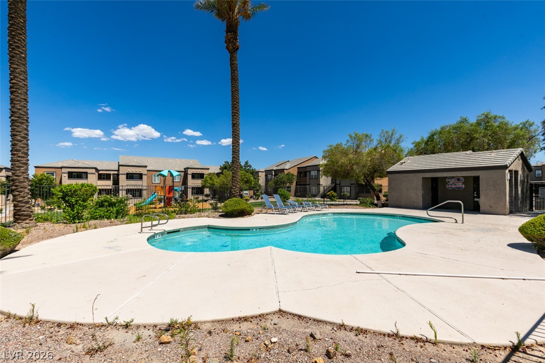 6650 West Warm Springs Road, Unit 2118 Las Vegas, NV 89118 - Photo 35 of 41 A refreshing pool awaits, surrounded by lush landscaping and a nearby playground for family enjoyment.