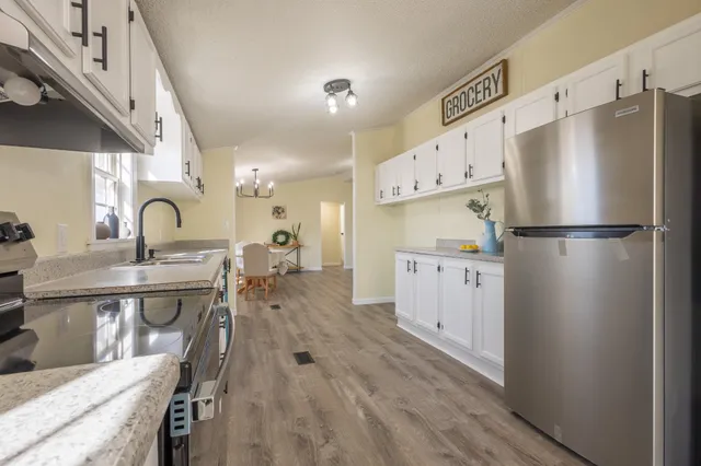 a kitchen with white cabinets and stainless steel appliances