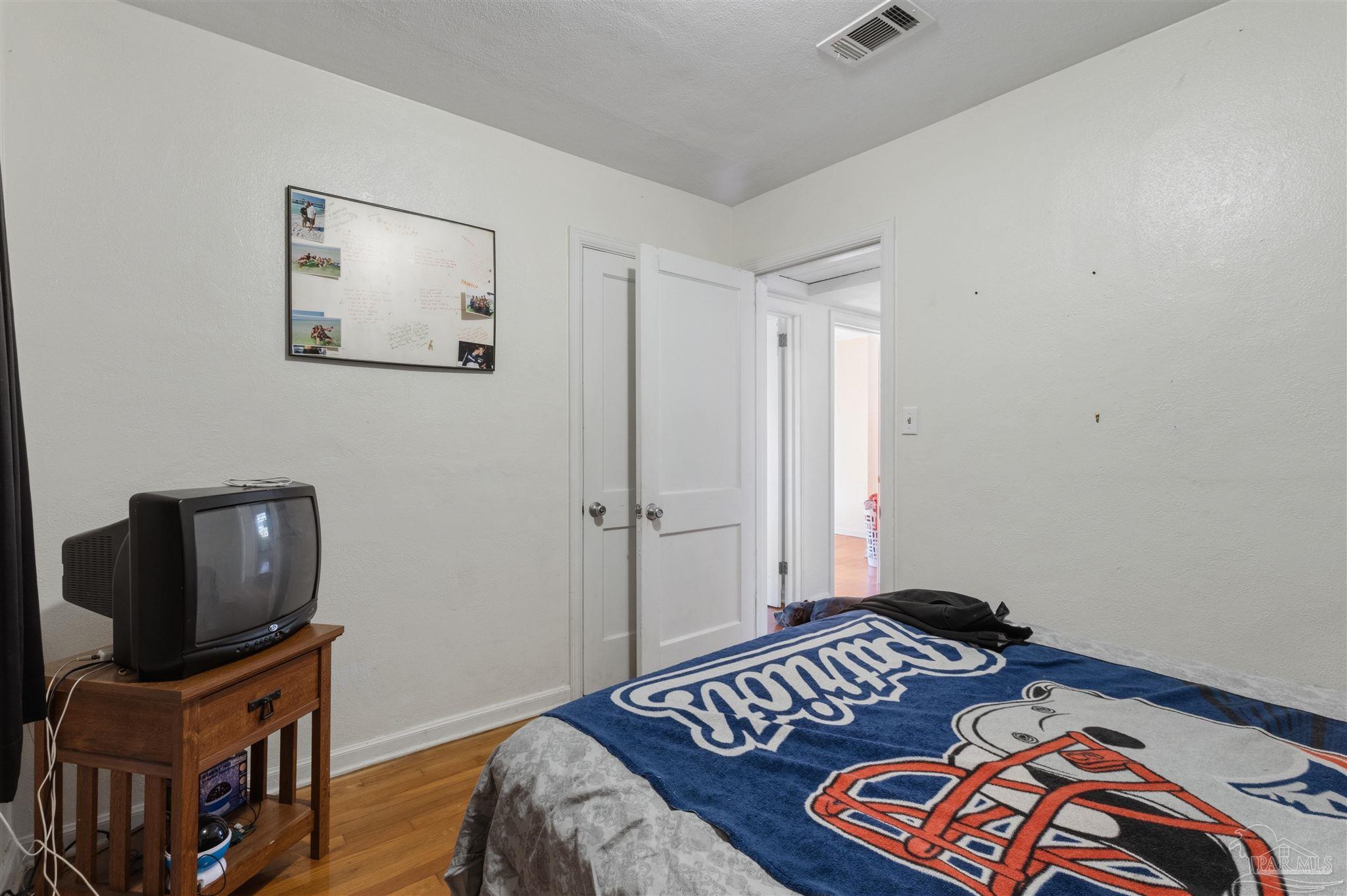 116 Rue Max Street Pensacola, FL 32507 - Photo 13 of 20 a bedroom with a bed and wooden floor
