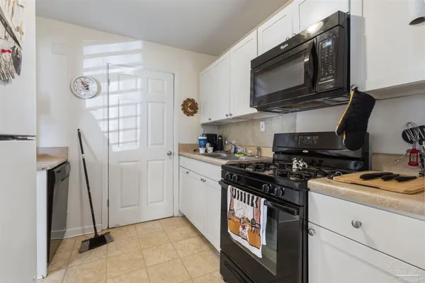 a kitchen with stainless steel appliances a stove a microwave a sink and cabinets
