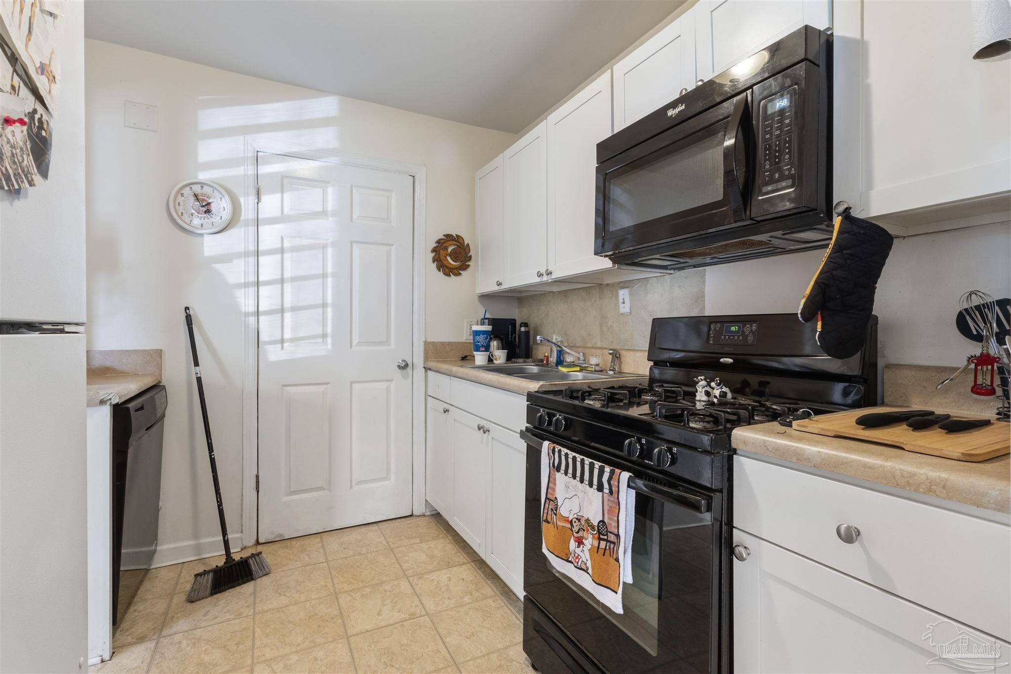 116 Rue Max Street Pensacola, FL 32507 - Photo 5 of 20 a kitchen with stainless steel appliances a stove a microwave a sink and cabinets