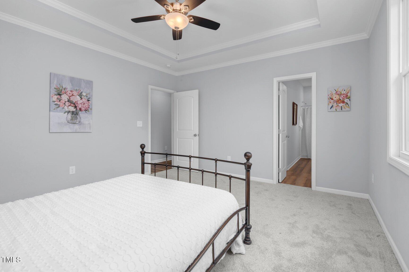 9506 South Beaver Crk Way Middlesex, NC 27557 - Photo 21 of 28 a bedroom with a large bed and a chandelier