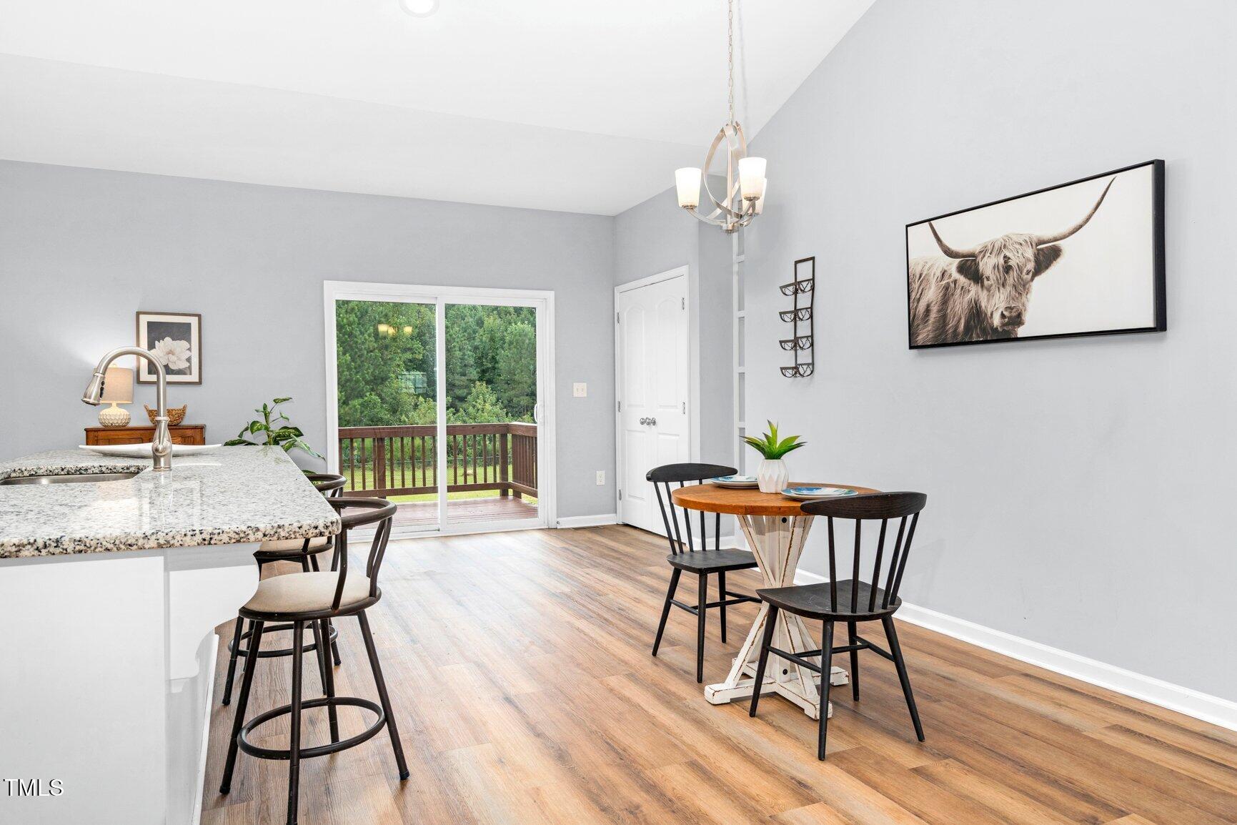 9506 South Beaver Crk Way Middlesex, NC 27557 - Photo 9 of 28 a dining room with furniture a chandelier and wooden floor