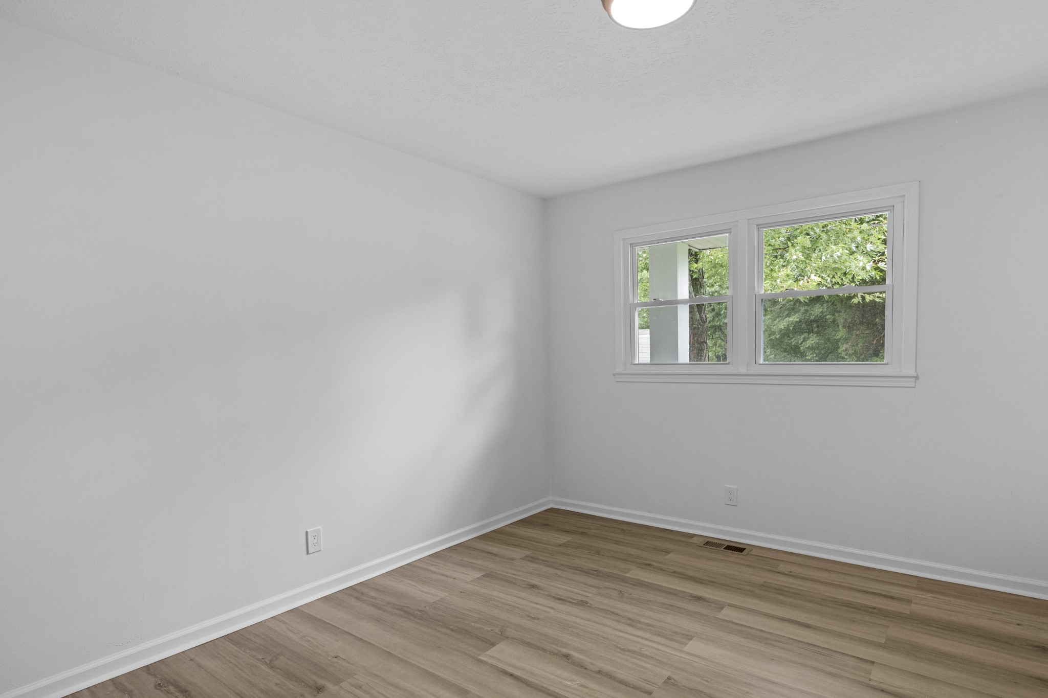 135 Hurricane Loop Tennessee Ridge, TN 37178 - Photo 16 of 29 a view of an empty room with wooden floor and a window