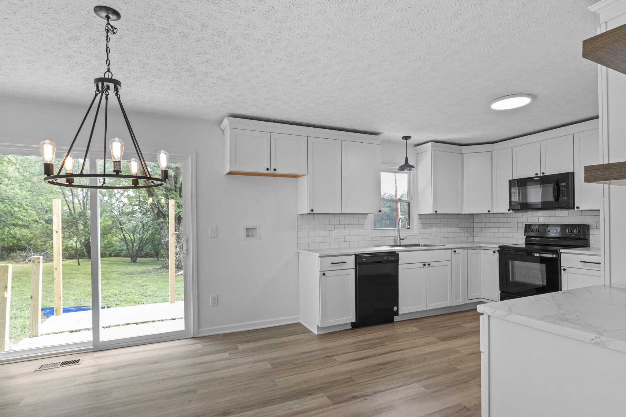 135 Hurricane Loop Tennessee Ridge, TN 37178 - Photo 2 of 29 a kitchen with stainless steel appliances granite countertop a sink a stove a refrigerator and island with wooden floor
